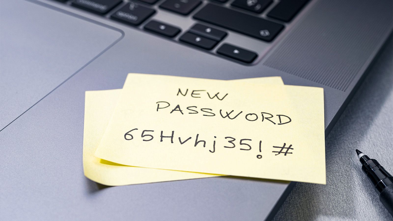 A sticky note with a new password on a laptop